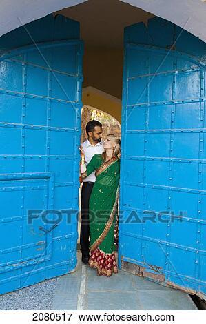 Portrait of a mixed race couple with her wearing a sari standing in the doorway with large blue doors; ludhiana punjab india View Large Photo Image Stock Photo - Portrait of a mixed race couple with her wearing a sari standing in the doorway with large blue doors; ludhiana punjab india. Fotosearch