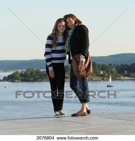 Picture - Portrait of a mother and daughter standing at the water's edge; oslo norway. Fotosearch
