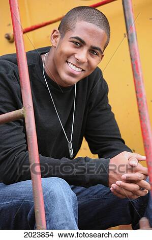 Picture - Portrait Of A Teenage Boy Sitting On A Yellow Train Car; Troutdale Oregon United States Of America. Fotosearch