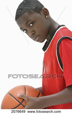 Portrait of a teenage boy wearing a red jersey holding a basketball; portland oregon united states of america View Large Photo Image Stock Photo - Portrait of a teenage boy wearing a red jersey holding a basketball; portland oregon united states of america. Fotosearch