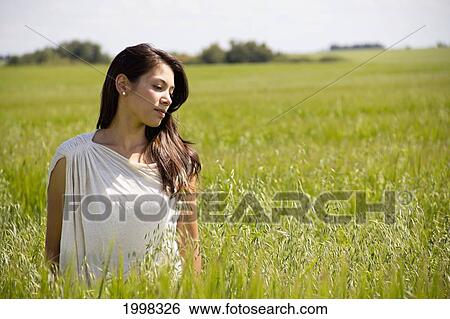 Portrait Of A Woman In A Field Of Tall Grass; Three Hills Alberta Canada View Large Photo Image Stock Photograph - Portrait Of A Woman In A Field Of Tall Grass; Three Hills Alberta Canada. Fotosearch