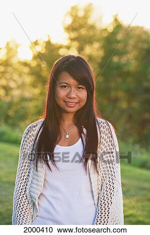 Portrait Of A Young Filipino Woman In A Park; Edmonton Alberta Canada View Large Photo Image Stock Image - Portrait Of A Young Filipino Woman In A Park; Edmonton Alberta Canada. Fotosearch