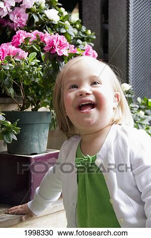 Portrait Of A Young Girl With Down Syndrome Beside Flower Pots; Vancouver British Columbia Canada View Large Photo Image Stock Image - Portrait Of A Young Girl With Down Syndrome Beside Flower Pots; Vancouver British Columbia Canada. Fotosearch
