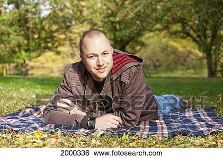 Stock Photograph - Portrait Of A Young Man In A Park; Edmonton Alberta Canada. Fotosearch