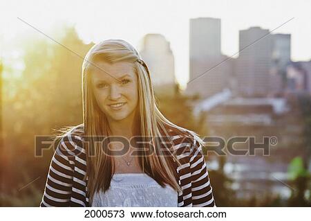 Portrait Of A Young Woman In A Park With The City Skyline In The Background; Edmonton Alberta Canada View Large Photo Image Stock Image - Portrait Of A Young Woman In A Park With The City Skyline In The Background; Edmonton Alberta Canada. Fotosearch