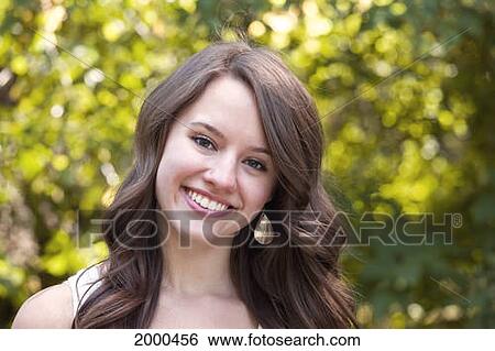 Stock Photograph - Portrait Of A Young Woman In A Park; Edmonton Alberta Canada. Fotosearch