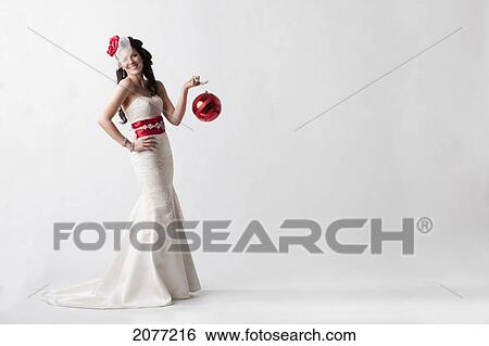 Portrait of a young woman wearing a white strapless formal dress with red accessories against a white background; nashville tennessee united states of america View Large Photo Image Stock Photograph - Portrait of a young woman wearing a white strapless formal dress with red accessories against a white background; nashville tennessee united states of america. Fotosearch