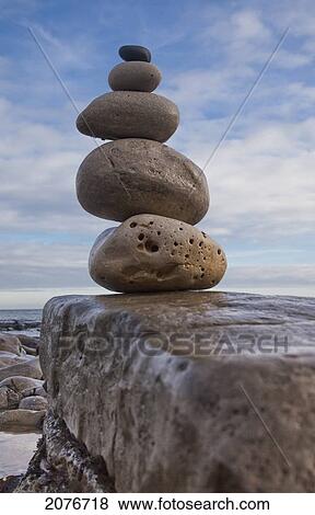 Stock Photo - Rocks balancing in a pile from largest to smallest on a boulder along the water's edge south shields tyne and wear england. Fotosearch