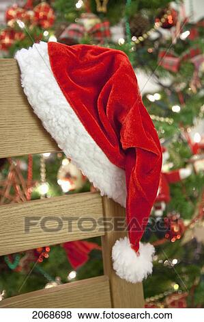 Stock Photo - Santa's Hat Hung On A Chair In Front Of A Christmas Tree; South Shields Tyne And Wear England. Fotosearch
