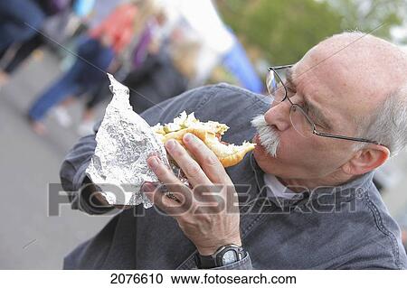 Senior man eating a hot dog; troutdale oregon united states of america View Large Photo Image Stock Image - Senior man eating a hot dog; troutdale oregon united states of america. Fotosearch