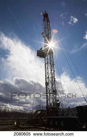 Silhouette of a drilling rig with sunburst blue sky and clouds near drayton valley; alberta canada View Large Photo Image Stock Photography - Silhouette of a drilling rig with sunburst blue sky and clouds near drayton valley; alberta canada. Fotosearch