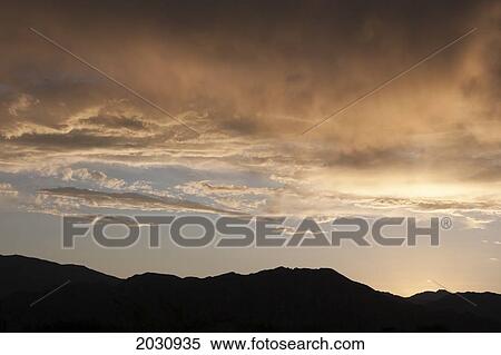 Silhouette Of Desert Mountain Range At Sunset With Glowing Clouds In The Sky; Palm Springs California United States Of America View Large Photo Image Stock Photography - Silhouette Of Desert Mountain Range At Sunset With Glowing Clouds In The Sky; Palm Springs California United States Of America. Fotosearch