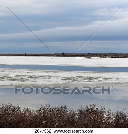 Snow and ice on a flat landscape with cloud reflecting in the water; churchill manitoba canada View Large Photo Image Stock Image - Snow and ice on a flat landscape with cloud reflecting in the water; churchill manitoba canada. Fotosearch