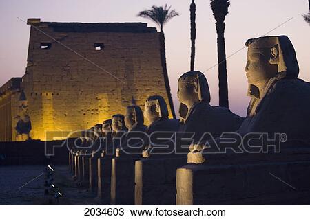 Stone Statues And The Luxor Temple On The East Bank Of Luxor Along The Nile River; Luxor Egypt View Large Photo Image Stock Image - Stone Statues And The Luxor Temple On The East Bank Of Luxor Along The Nile River; Luxor Egypt. Fotosearch