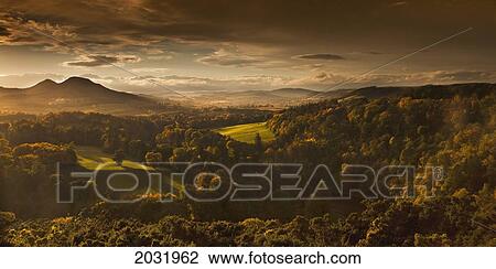 Stock Image - Sunlight Cast On Trees And Mountains Through The Clouds; Scots View Scottish Borders Scotland. Fotosearch