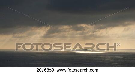 Sunlight through the storm clouds over the ocean; sayulita mexico View Large Photo Image Stock Photo - Sunlight through the storm clouds over the ocean; sayulita mexico. Fotosearch