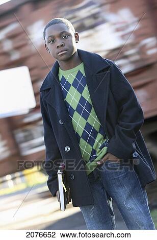 Stock Image - Teenage boy holding school book standing in front of moving train; portland oregon united states of america. Fotosearch