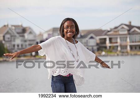 Picture - Teenage Girl Balancing On The Rail Of A Pier In A Residential Lake Neighborhood; Edmonton Alberta Canada. Fotosearch