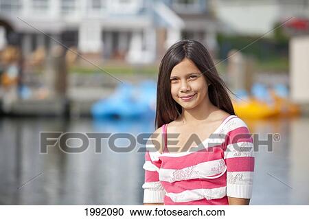 Stock Image - Teenage Girl On Lakeshore Of Residential Lake; Edmonton Alberta Canada. Fotosearch