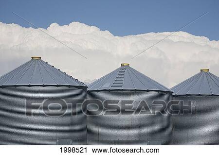 Three Grain Bins With Dramatic Thunder Storm Clouds In The Background And Blue Sky; Alberta Canada View Large Photo Image Stock Image - Three Grain Bins With Dramatic Thunder Storm Clouds In The Background And Blue Sky; Alberta Canada. Fotosearch