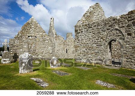 Stock Photo - Tombstones In A Cemetery And An Old Cathedral; Clonmacnoise County Offaly Ireland. Fotosearch