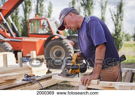Tradesman Working On Framing For New Home Construction; St. Albert Alberta Canada View Large Photo Image Stock Photo - Tradesman Working On Framing For New Home Construction; St. Albert Alberta Canada. Fotosearch