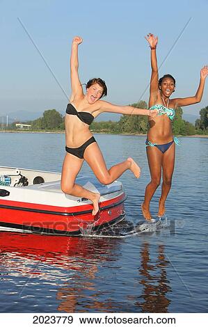 Two Teenage Girls Jumping Off The Back Of A Boat Into A River; Troutdale Oregon United States Of America View Large Photo Image Stock Photo - Two Teenage Girls Jumping Off The Back Of A Boat Into A River; Troutdale Oregon United States Of America. Fotosearch