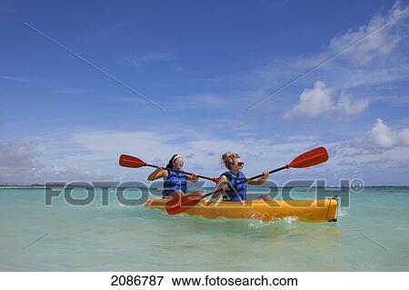 Two women in lifejackets paddling in a yellow boat; punta cana la altagracia dominican republic View Large Photo Image Stock Photo - Two women in lifejackets paddling in a yellow boat; punta cana la altagracia dominican republic. Fotosearch