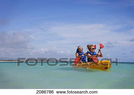 Two women in lifejackets paddling in a yellow boat; punta cana la altagracia dominican republic View Large Photo Image Stock Photograph - Two women in lifejackets paddling in a yellow boat; punta cana la altagracia dominican republic. Fotosearch