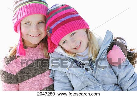 Stock Image - Two Young Girls In Pink Striped Hats Hugging; Troutdale Oregon United States Of America. Fotosearch