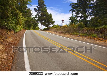 Stock Image - Umpqua River Lighthouse And A Two Lane Road; Oregon United States Of America. Fotosearch