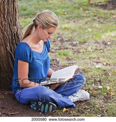 Woman Reading Her Bible In A Park Beside A Tree; Edmonton Alberta Canada View Large Photo Image Stock Image - Woman Reading Her Bible In A Park Beside A Tree; Edmonton Alberta Canada. Fotosearch