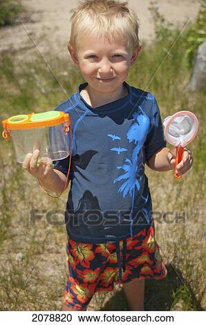 Stock Image - Young boy with bug catcher; lake tahoe california united states of america. Fotosearch