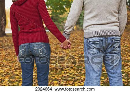 Young Couple Holding Hands While Standing In A Park In Autumn; Edmonton Alberta Canada View Large Photo Image Picture - Young Couple Holding Hands While Standing In A Park In Autumn; Edmonton Alberta Canada. Fotosearch
