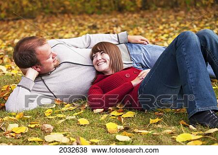 Young Couple Laying On The Grass In A Park In Autumn; Edmonton Alberta Canada View Large Photo Image Stock Photo - Young Couple Laying On The Grass In A Park In Autumn; Edmonton Alberta Canada. Fotosearch