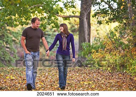 Young Couple Walking In A Park Together In Autumn; Edmonton Alberta Canada View Large Photo Image Stock Image - Young Couple Walking In A Park Together In Autumn; Edmonton Alberta Canada. Fotosearch