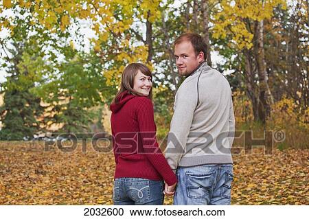 Young Couple Walking Together In A Park In Autumn; Edmonton Alberta Canada View Large Photo Image Stock Image - Young Couple Walking Together In A Park In Autumn; Edmonton Alberta Canada. Fotosearch