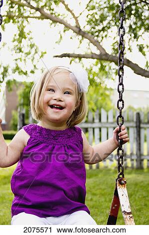 Stock Image - Young Girl On A Swing; Three Hills Alberta Canada. Fotosearch