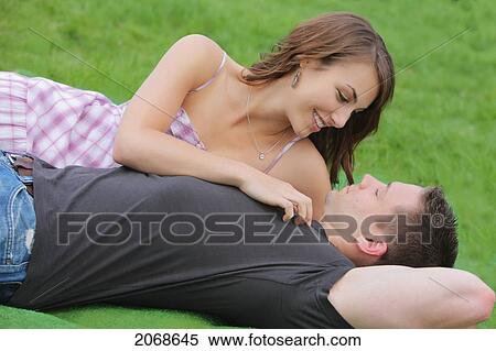 Young Man And Woman Laying On The Grass; Troutdale Oregon United States Of America View Large Photo Image Stock Photography - Young Man And Woman Laying On The Grass; Troutdale Oregon United States Of America. Fotosearch