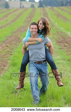 Stock Image - Young Man Giving Young Woman A Piggy Back Ride; Troutdale Oregon United States Of America. Fotosearch