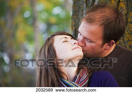 Young Married Couple Embracing And Kissing Beside A Tree In A Park In Autumn; Edmonton Alberta Canada View Large Photo Image Stock Photo - Young Married Couple Embracing And Kissing Beside A Tree In A Park In Autumn; Edmonton Alberta Canada. Fotosearch