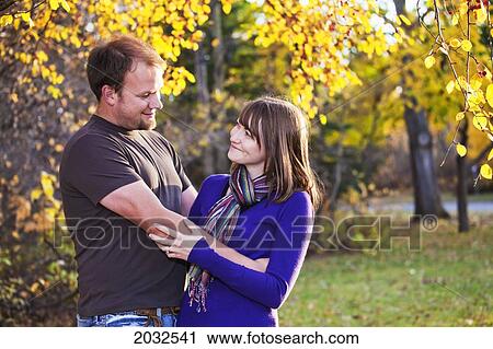 Stock Image - Young Married Couple Embracing In A Park; Edmonton Alberta Canada. Fotosearch