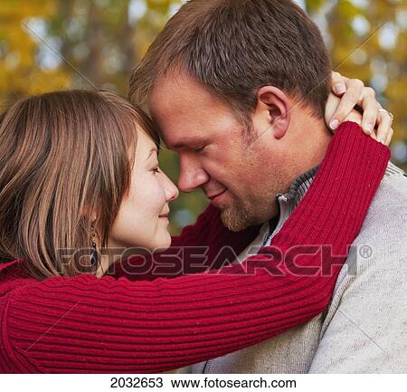 Stock Image - Young Married Couple Embracing Intimately In A Park In Autumn; Edmonton Alberta Canada. Fotosearch