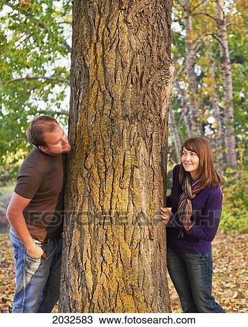 Young Married Couple Peaking At Each Other Around A Tree In A Park In Autumn; Edmonton Alberta Canada View Large Photo Image Stock Image - Young Married Couple Peaking At Each Other Around A Tree In A Park In Autumn; Edmonton Alberta Canada. Fotosearch