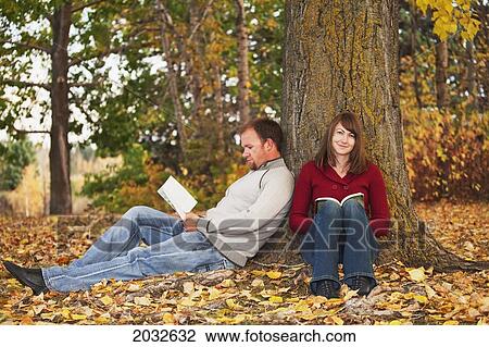 Young Married Couple Reading In A Park In Autumn; Edmonton Alberta Canada View Large Photo Image Stock Image - Young Married Couple Reading In A Park In Autumn; Edmonton Alberta Canada. Fotosearch
