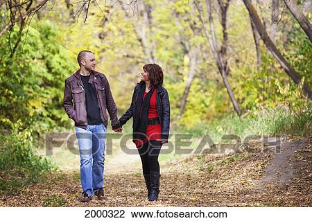 Young Married Couple Walking And Talking Together In A Park In Autumn; Edmonton Alberta Canada View Large Photo Image Stock Image - Young Married Couple Walking And Talking Together In A Park In Autumn; Edmonton Alberta Canada. Fotosearch