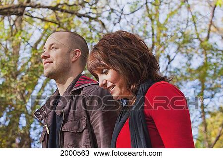 Stock Image - Young Married Couple Walking And Talking Together In A Park; Edmonton Alberta Canada. Fotosearch