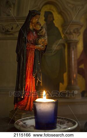 A candle burning by a small sculpture of a woman holding a child; kelso scottish borders scotland View Large Photo Image Stock Photograph - A candle burning by a small sculpture of a woman holding a child; kelso scottish borders scotland. Fotosearch