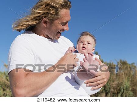 A father holding his infant; tarifa cadiz andalusia spain View Large Photo Image Stock Image - A father holding his infant; tarifa cadiz andalusia spain. Fotosearch
