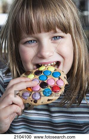 Stock Image - A girl eating a candy cookie; gold coast queensland australia. Fotosearch